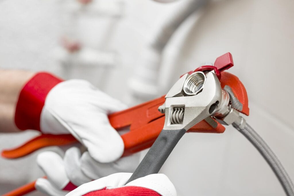 Plumber holding pipe wrenches for an emergency repair in Pompano Beach