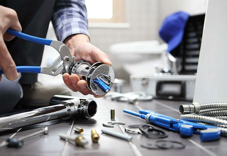Technician repairing a plumbing fixture with professional tools in Pompano Beach