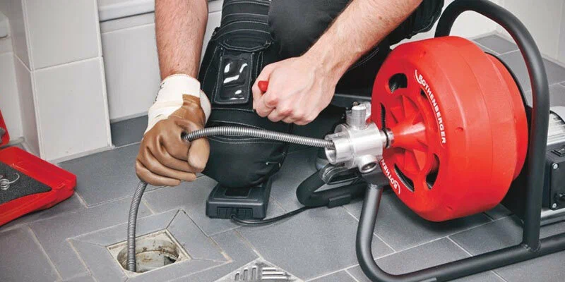 Plumber using a drain-cleaning machine in Pompano Beach