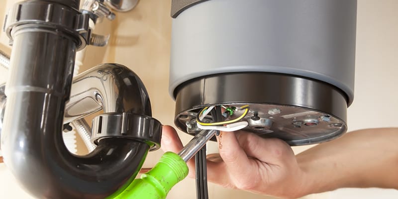 Technician repairing the heating element of a water heater in Pompano Beach