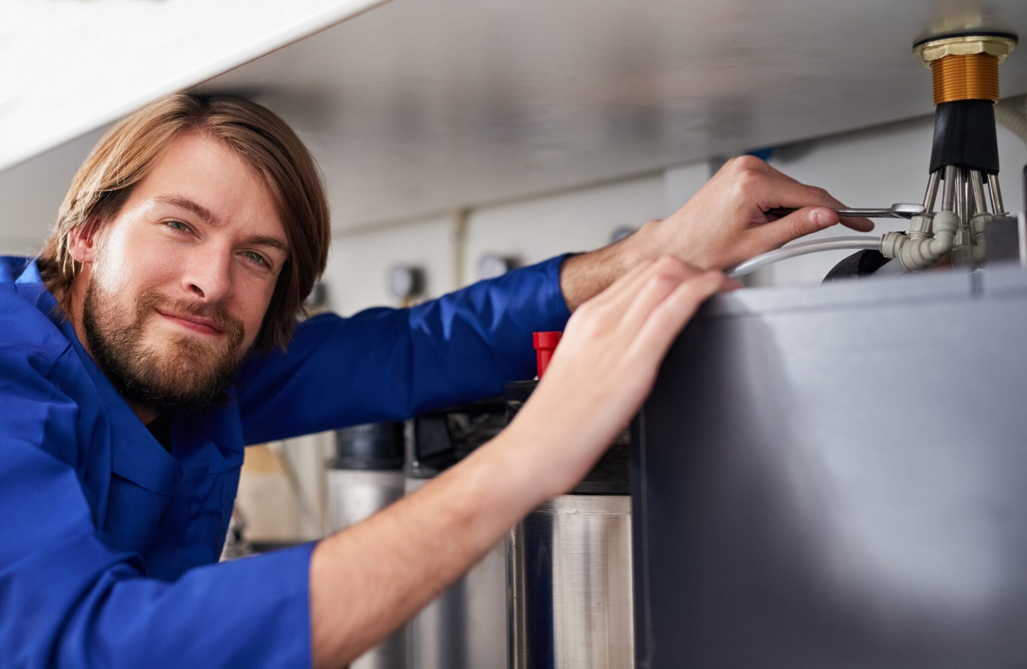 Technician servicing a residential water heater tank in Pompano Beach