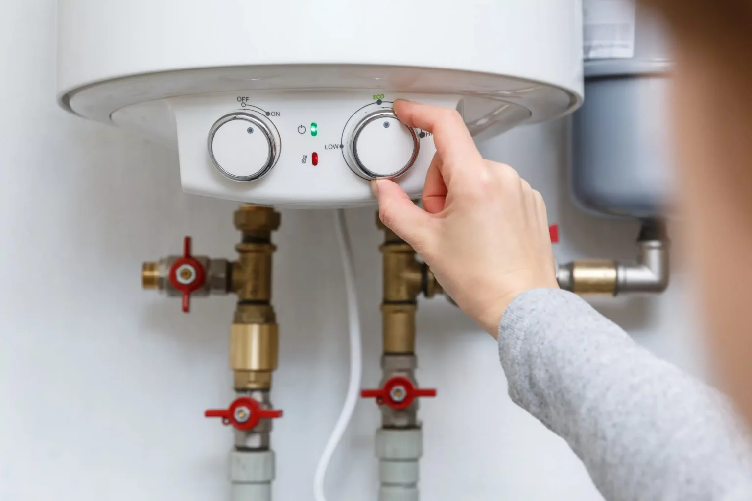 Homeowner adjusting the temperature controls on a water heater in Pompano Beach